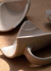 Broken ceramic mug pieces on a wooden surface