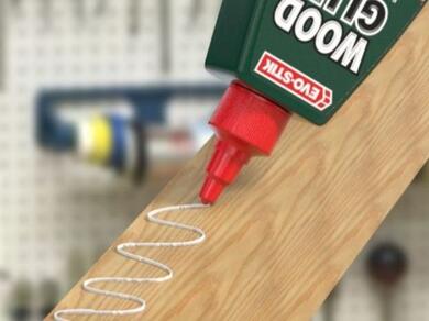 Applying wood adhesive to a timber surface before joining wooden components in a woodworking project.