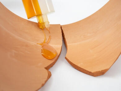 Applying repair adhesive to a broken ceramic item before reassembly