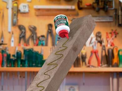 Applying wood adhesive to timber in a workshop for assembly and joinery projects