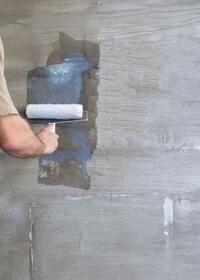 Applying diluted PVA to a wall with a roller to seal and prepare the surface before decorating